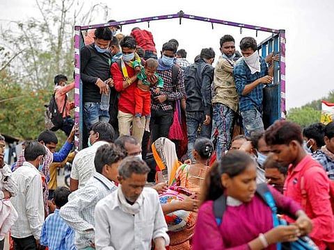 Migrant workers and their families board a truck to return to their villages. India has chosen an odd combination of strategies in its fight against the coronavirus — a harsh lockdown on economic activity and a meagre fiscal response to the loss of jobs and incomes.