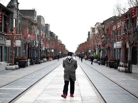A man wearing a protective face mask walks in a historic district of Beijing, that is normally crowded with tourists, following the outbreak of coronavirus disease (COVID-19) in Beijing, China, March 26, 2020. 