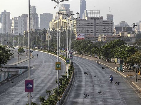 A motorcyclist rides along the near-empty Marine Drive during a lockdown imposed due to the coronavirus in Mumbai on Wednesday, March 25, 2020.