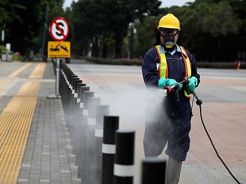 A worker sprays disinfectant at the pedestrian walkway at Senayan Sports Complex amid coronavirus outbreak, in Jakarta, Indonesia, Thursday, March 26, 2020. 