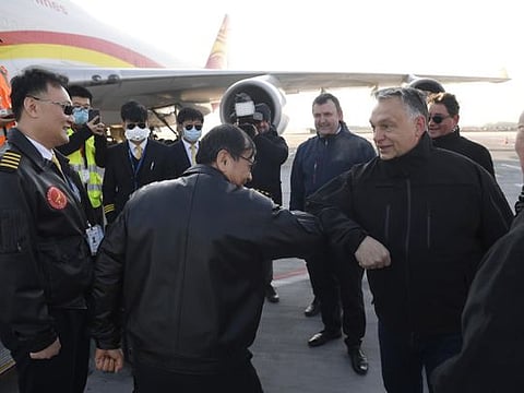 Hungarian Prime Minister Viktor Orban, second right, welcomes the staff of the Chinese Suparna Airlines at Liszt Ferenc International Airport in Budapest, Hungary, Tuesday, March 24, 2020. The delivery contains 3 million face masks, 100,000 tests and 86 ventilators to combat the COVID-19 coronavirus. In the centre Hungarian Minister of Innovation and Technology Laszlo Palkovics. (Tamas Kovacs/MTI via AP)