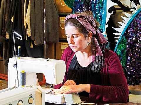 Corrina Bakken, the Minnesota Opera's costume director, sews masks for hospital workers in her office, Minneapolis, on March 24, 2020. With overrun hospitals facing an acute shortage of masks, people are pulling out their sewing machines to fill the void.