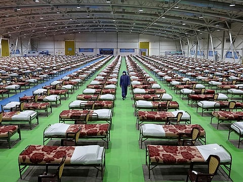 A member of the Iranian army walks past rows of beds at a temporary 2,000-bed hospital for COVID-19 coronavirus patients set up by the army at the international exhibition center in northern Tehran, Iran, on Thursday, March 26, 2020. 