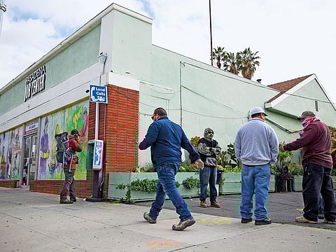 Job seekers wait outside the Pasadena Community Job Centre in Pasadena, California. The Global jobs slump has put US payrolls in the spotlight.