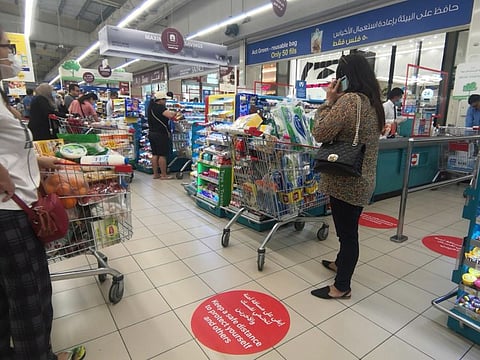 Signs on the ground at Carrefour Ajman City Centre to ensure customers keep a safe distance from each other