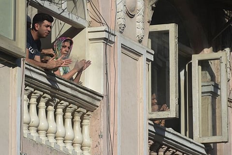 People gather in balconies of a residential building to clap to thank essential service providers during a one-day Janata (civil) curfew imposed amid concerns over the spread of the COVID-19 novel coronavirus, in Mumbai 