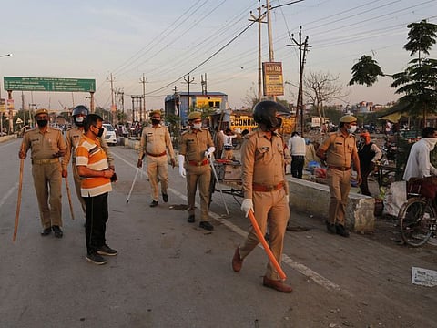 Policemen ask vegetable vendor to leave a market during lockdown to check the spread of the coronavirus, in Prayagraj, India, April 4.