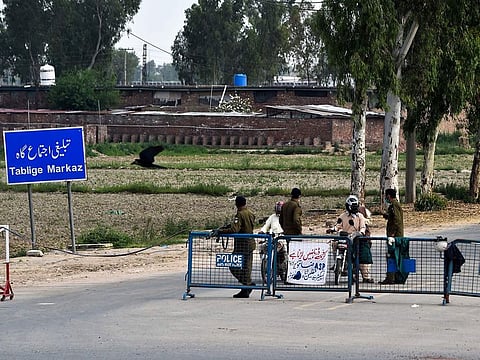 Policemen wearing facemasks check motorcyclists at the Tablighi Markaz checkpoint during a government-imposed nationwide lockdown as a preventive measure against the COVID-19 coronavirus, in Lahore on April 5, 2020.