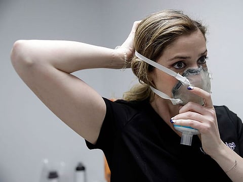 Dr. Diana Sedler, a periodontist, puts on a mask made by a 3D printer, designed at her family's business, Burbank Dental Lab Monday, April 6, 2020, in Burbank, California.