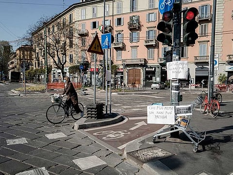 A shopping cart on a corner in Milan, Tuesday, April 7, 2020, contains food for those in need, while also asking for donations.
