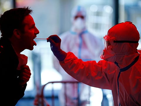 A medical employee collects a smear at a special corona test center for public service employees such as police officers, nurses and firefighters during a media presentation as the spread of the coronavirus disease (COVID-19) continues, in Cologne, Germany, March 31, 2020. 