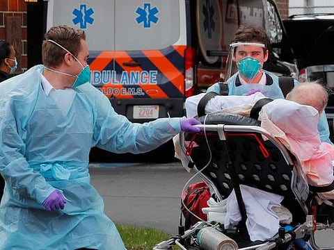 Cataldo Ambulance medics bring a patient who has tested positive for the coronavirus disease (COVID-19) to the ambulance at an assisted living facility in Chelsea, Massachusetts, US, on April 10, 2020.