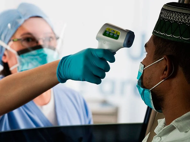 A staffer checks a man's temperature