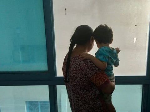 Victor Solanki’s mother and son at the single room rented by the family in Sharjah