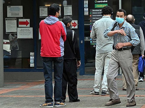 People queue up to receive benefit payouts, including unemployment and small business support, at a Centerlink payment centre in downtown Sydney on April 14, 2020.