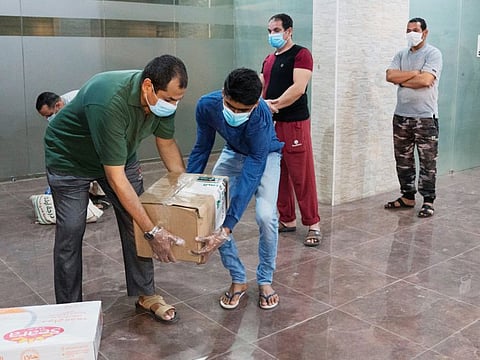 Expatriates in lockdown at a quarantined building, receive food from a Kuwaiti charity in Farwaniya, Kuwait on April 6