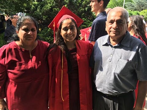 Minnoli Aya poses with her parents Raj and Madhvi on her graduation day in this undated handout photo provided by the family to Reuters on April 13, 2020. Courtesy of Minnoli Aya