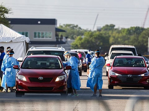 Health care workers gather samples at a drive-thru coronavirus testing site in Tampa, Fla., March 26, 2020.