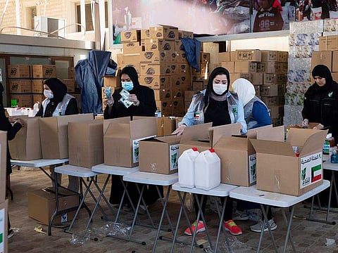 Kuwaiti volunteers wear protective masks as they fill charity boxes with essential household supplies to distribute to the needy, following the outbreak of the coronavirus disease (COVID-19), in Adeliah, Kuwait April 4, 2020. 