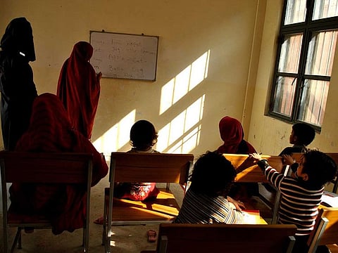 In this Nov. 8, 2018 file photo, a Pakistani woman prisoner teaches fellow inmates and their children at a central jail in Mardan, Pakistan. 