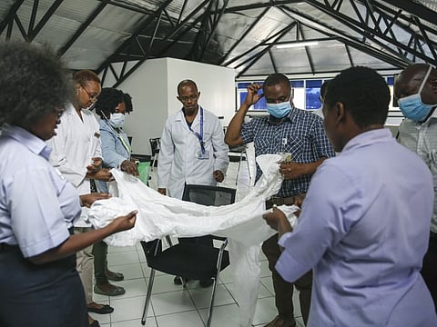 In this April 2 file photo, a health inspection officer shows doctors how to use protective equipment before they head to a ward at Mbagathi hospital for patients under quarantine with confirmed cases of the coronavirus, at Kenyatta National Hospital in Nairobi, Kenya. 