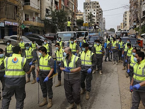 In this March 27 file photo, members of the Islamic Health Society, an arm of the Iran-backed militant Hezbollah group prepare to spray disinfectant as a precaution against the coronavirus in Beirut.