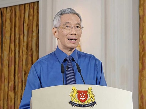 In this handout photo released Tuesday, Apr. 21, 2020, by Singapore's Ministry of Communication and Information, Prime Minister Lee Hsien Loong provides an update on the COVID-19 situation in the city state. Singapore has announced that it would extend its lockdown by another four weeks after a sharp upsurge in COVID-19 cases in recent days. 