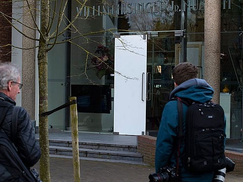 In this Monday March 30, 2020 file photo, journalists look at the damaged glass door of the Singer Museum in Laren, Netherlands, where a Van Gogh painting was stolen.