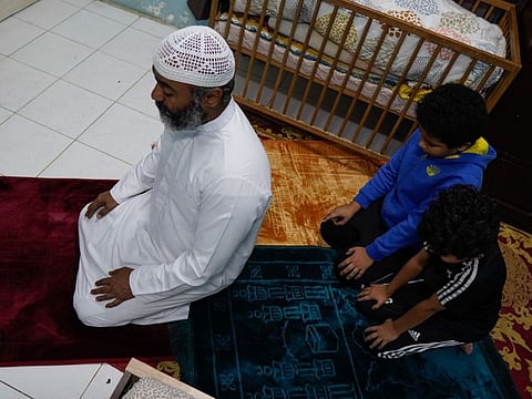 Family pray at their residence in the UAE, April 21, 2020