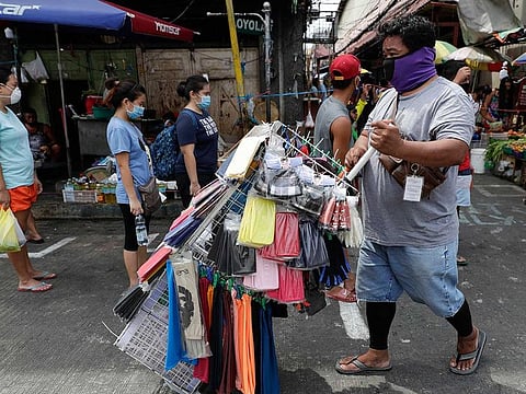 A man peddles face masks at a public market during an enhanced community quarantine to prevent the spread of the new coronavirus in Manila, Philippines on Thursday April 23, 2020. 