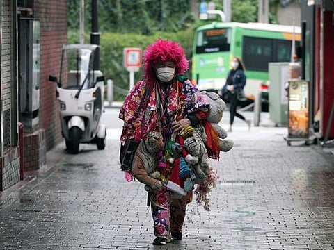A man  wearing a mask and a colourful attire to help stop the spread of the new coronavirus walks in the Shinjuku Ward in Tokyo 