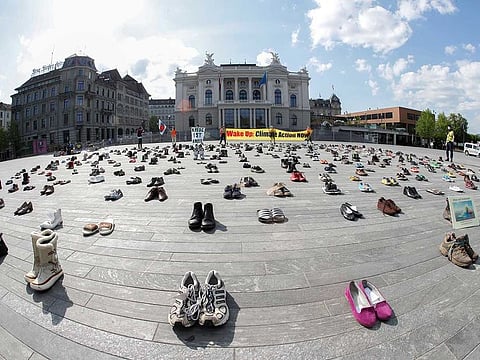Environmental activists of Swiss Klimastreik Schweiz movement hold banners, one of them reads: "Crisis is crisis", after placing shoes in place of live participants to demonstrate against climate change, as the spread of the coronavirus disease (COVID-19) continues, in front of the opera house on the Sechselaeutenplatz square in Zurich, Switzerland April 24, 2020.  