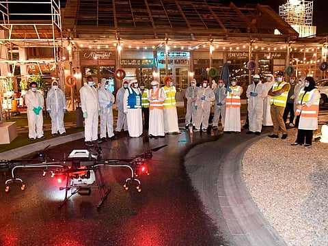 Sterilisation teams pose with a modified drone in Al Khawaneej