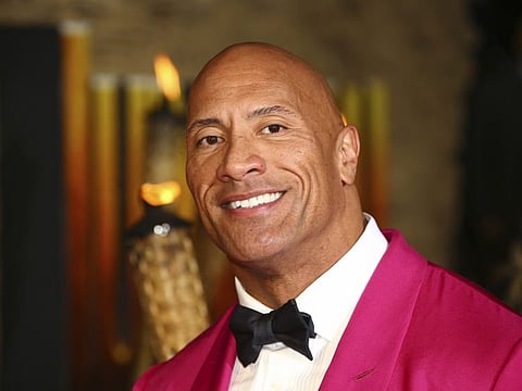 FILE - In this Dec. 5, 2019 file photo, actor Dwayne Johnson poses for photographers upon arrival at the premiere of the film 'Jumanji The Next Level', in central London.   Johnson will revisit his younger years in a new NBC comedy series called “The Rock,” which is the retired pro wrestler's nickname. NBC said Saturday, Jan. 11, 2020  that it's ordered 11 episodes of the show inspired by Johnson, who will appear and also serve as an executive producer.  (Photo by Joel C Ryan/Invision/AP)