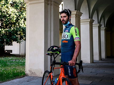 Umberto Marengo poses with his bicycle on a delivery day in Collegno, near Turin.