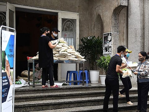 A woman (R) wearing a face mask stands in a queue for free rice at the Hanoi. Data from parts of Asia, which includes China, Korea, Vietnam and Taiwan, and Poland in Europe, where coronavirus outbreaks have been brought under control, have been stronger than what economists had earlier expected.