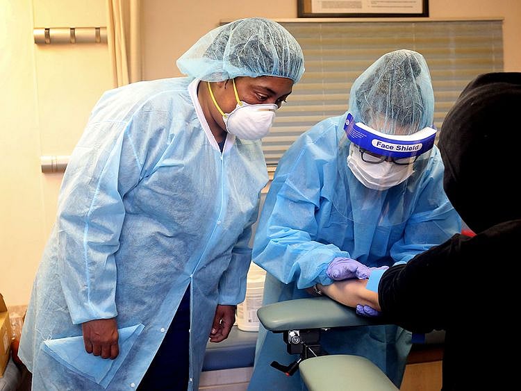Phlebotomists draw blood from people getting tested for coronavirus antibodies
