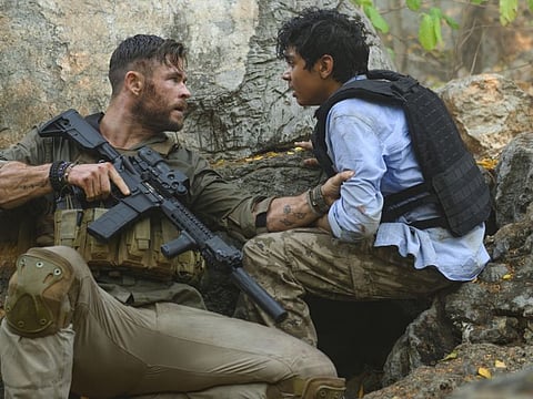 This image released by Netflix shows Chris Hemsworth, left, and Rudhraksh Jaiswal in a scene from "Extraction," premiering this week on Netflix. (Jasin Boland/Netflix via AP)