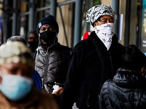 People wait in line outside a bank in the Bronx, New York, on April 6, 2020. 