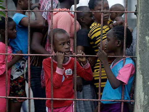 Children of Makoko Slum wait for their food packages distributed by the Nigerian Red Cross, for those under coronavirus related movement restrictions, in Lagos, Nigeria, Saturday, April 25, 2020.