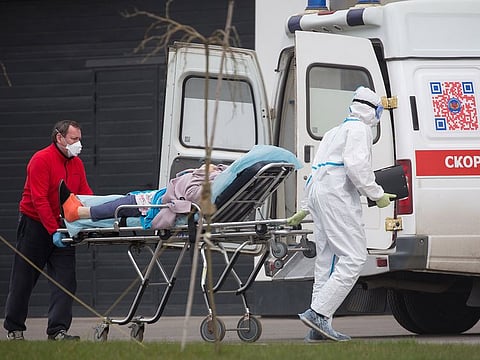 Medical workers wearing personal protective equipment (PPE) wheel a trolley bed with a COVID-19 patient from an ambulance into the Novomoskovsky multi-specialty hospital complex, in the Kommunarka settlement in Moscow. 
