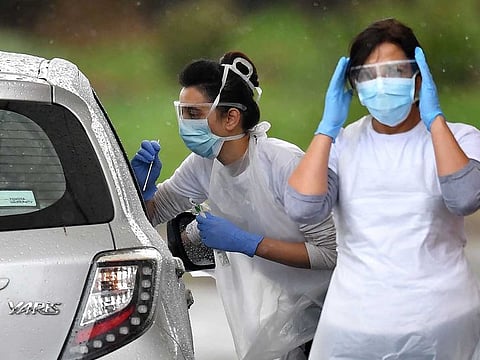 A medical worker tests a key worker for the novel coronavirus COVID-19 at a drive-in testing facility at the Chessington World of Adventures Resort in Greater London on April 28, 2020.