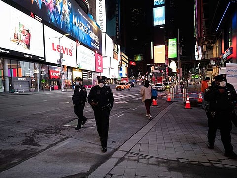 Police officers patrol New York's Times Square on foot, Wednesday night, April 29, 2020, during the coronavirus pandemic. President Donald Trump said Wednesday the federal government will not be extending its coronavirus social distancing guidelines once they expire Thursday. 