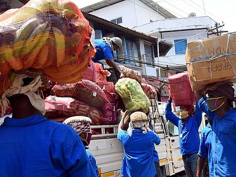 Labourers work at the Ernakulam market during the government imposed nationwide lockdown as a preventive measure against the COVID-19 coronavirus in Kochi on Thursday. 