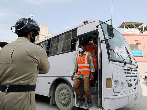 A police officer wears a smart helmet as he uses it to test the temperature of workers in Dubai. 