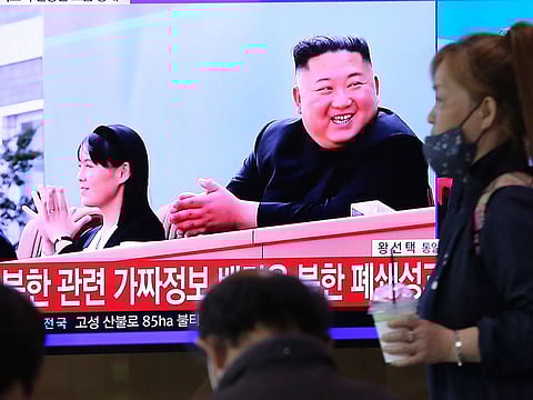 A woman passes by a TV screen showing an image of North Korean leader Kim Jong Un and his sister Kim Yo Jong during a news program at the Seoul Railway Station in Seoul, South Korea, Saturday, May 2, 2020. 