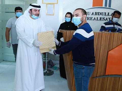 Dr Yaqoub Mousa, Chairman of Bu Abdullah Group, distributes masks and sanitisers among workers at his office in Ajman.