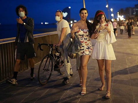People walk by the sidewalk of Barceloneta beach, amid the coronavirus disease (COVID-19) outbreak, in Barcelona, Spain, May 4, 2020. 