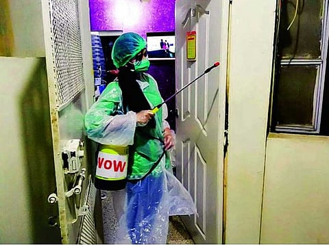 A worker of Voice of Women, a Karachi-based organisation, spraying as part of the disinfection campaign in Karachi. 
