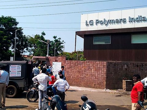 Policemen stand guard as people gather in front of an LG Polymers plant following a gas leak incident in Visakhapatnam on May 7, 2020. Gas had leaked out of two 5,000-tonne tanks that had been unattended due to India's coronavirus lockdown in place since late March. 